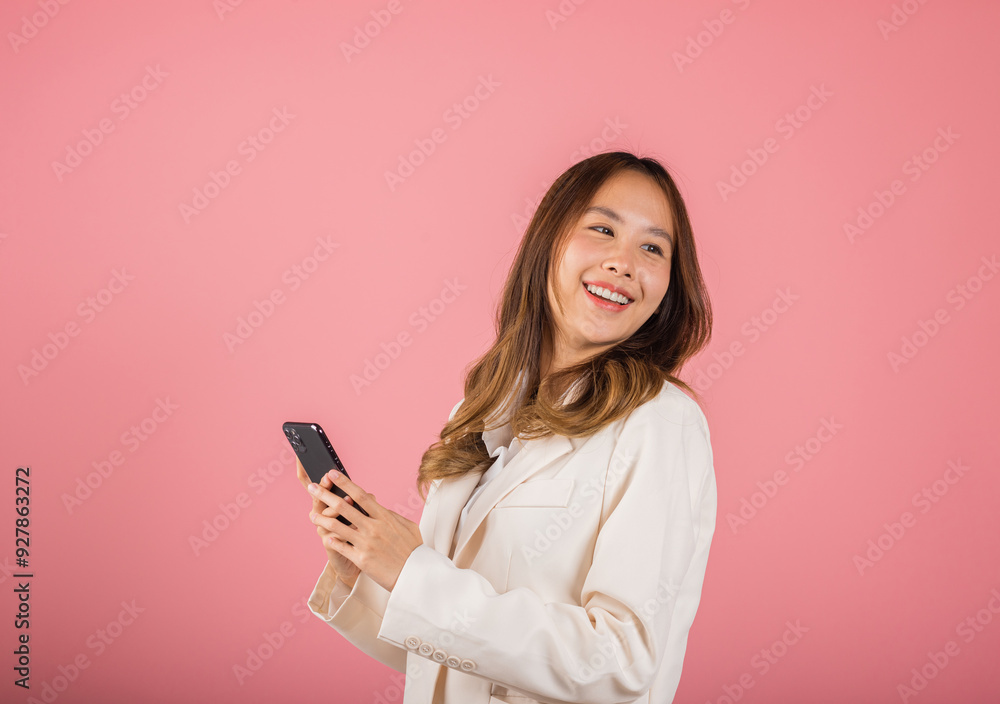 Happy Asian portrait beautiful business young woman teen smiling excited using smart mobile phone studio shot isolated on pink background, Thai female surprised making winner gesture on smartphone Happy Asian portrait beautiful business young woman teen smiling excited using smart mobile phone studio shot isolated on pink background, Thai female surprised making winner gesture on smartphone