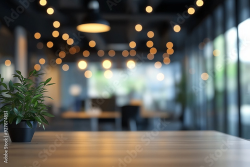 Wooden table with potted plant in foreground, blurred office background with bokeh lights for modern coworking space or cafe concept