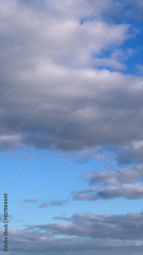 The video shows a sky filled with a mixture of white and gray clouds of various sizes and shapes, creating a dynamic pattern. The video shows a sky filled with a mixture of white and gray clouds of various sizes and shapes, creating a dynamic pattern.