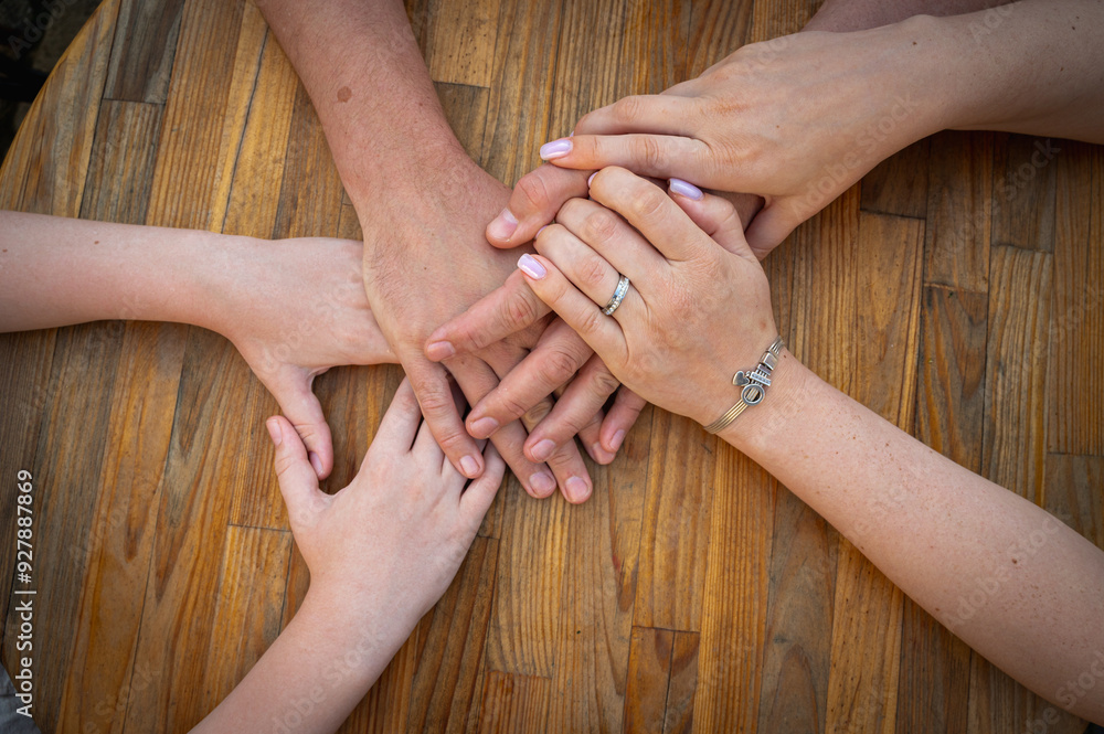 holding hands, family hands of mother father and child on wooden surface, top view holding hands, family hands of mother father and child on wooden surface, top view