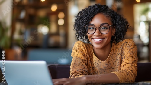 Ritratto di una giovane donna sorridente, che lavora in smart working. Il suo sorriso spontaneo e i capelli mossi trasmettono un senso di felicità e naturalezza.