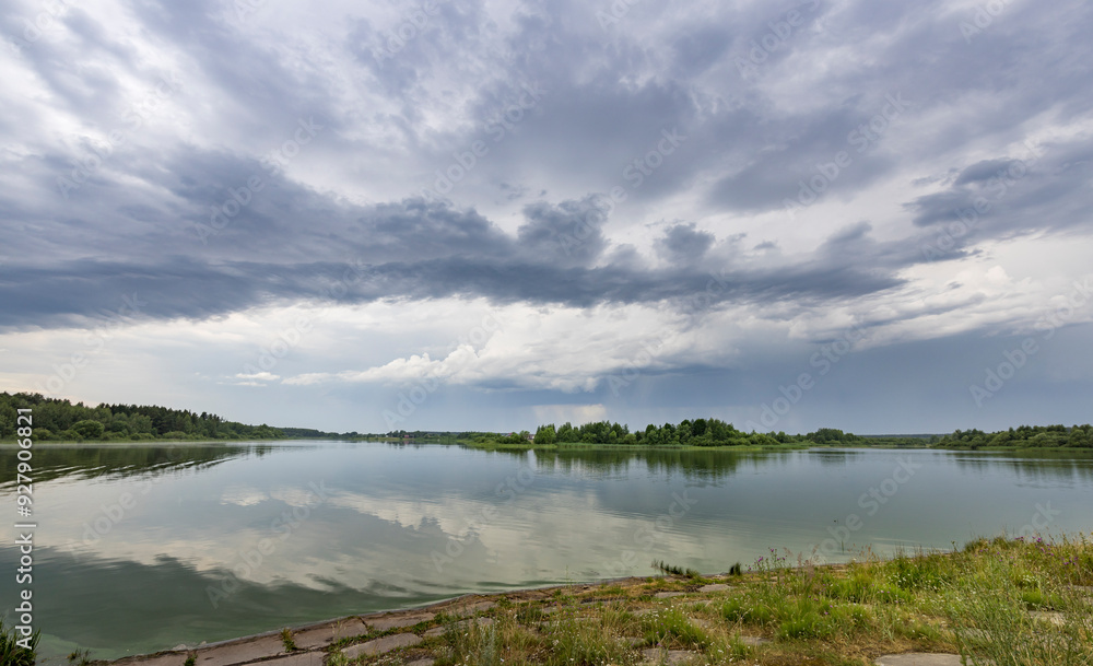 A cloudy sky over a lake with a reflection of the sky in the water