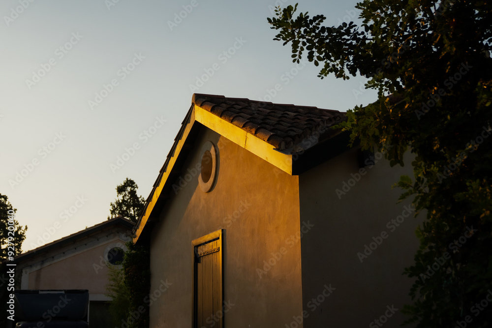 Greek house exterior design in hot summer evening sunset sun beams and reflection on painted doors Greek house exterior design in hot summer evening sunset sun beams and reflection on painted doors