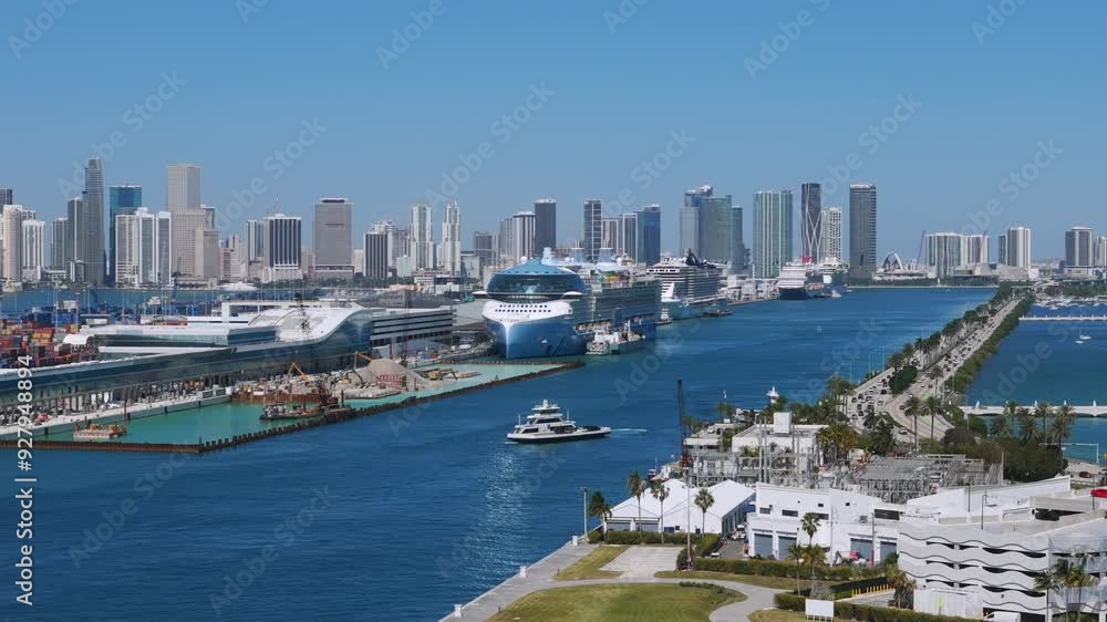 Panoramic view of Port Miami with multiple cruise ships docked at port. Background of skyline of Downtown with various high-rise buildings. Calm water and clear sky Panoramic view of Port Miami with multiple cruise ships docked at port. Background of skyline of Downtown with various high-rise buildings. Calm water and clear sky