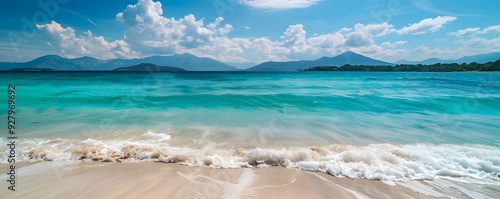 White Waves Crashing on a Sandy Beach with Mountains in the Background