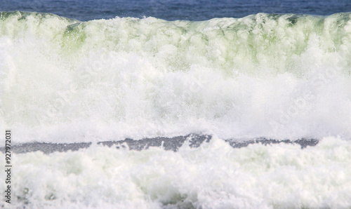 Large Breaking waves white sea foam rolling toward the shore photo