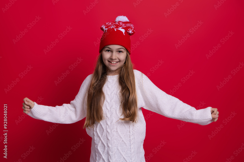 Happy childhood. Teen girl in Christmas hat. Winter fashion style. Girl in knitwear. Portrait of teen child wearing warm winter clothes. Girl kid wear warm hat isolated on red. Winter wonderland Happy childhood. Teen girl in Christmas hat. Winter fashion style. Girl in knitwear. Portrait of teen child wearing warm winter clothes. Girl kid wear warm hat isolated on red. Winter wonderland