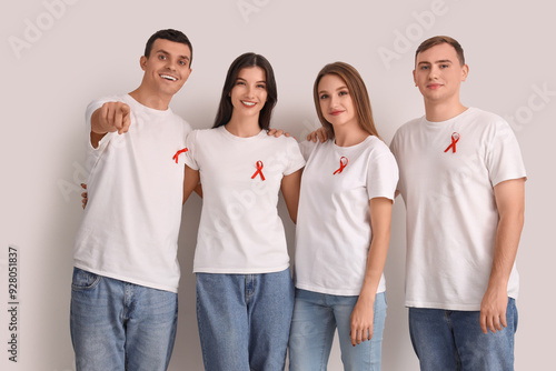 Group of young people with red ribbons on white background. World AIDS day co...