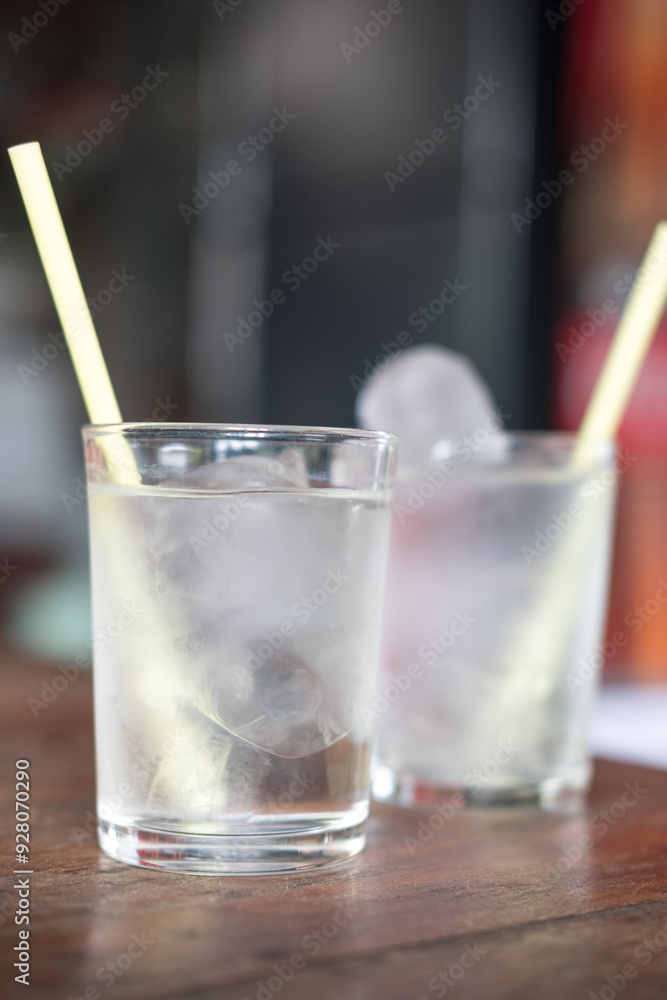 Glass of water on a wood table in a restaurant Glass of water on a wood table in a restaurant