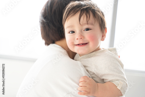 お母さんに抱っこをされて笑っている男の子の赤ちゃん photo