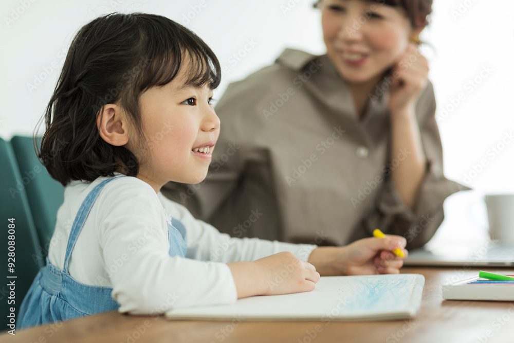 お絵かきする女の子と母親