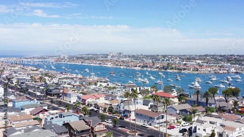 Aerial paralax shot showing sailboats moored along the Balboa Peninsula in Newport Beach, California photo