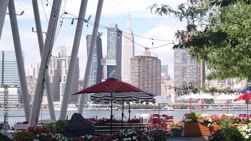 New York City waterfront skyline, Manhattan Midtown buildings, riverfront skyscrapers by East river water. Waterside cityscape view, Hunters Point pier columns, Long Island, Queens. United States.