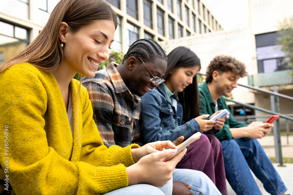 Group of happy multiracial teenage college friend students ignoring each other looking at mobile phone. Smartphone addiction. Group of happy multiracial teenage college friend students ignoring each other looking at mobile phone. Smartphone addiction.
