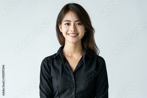 A Smiling Asian woman in black business attire radiates professionalism and approachability, with her well lit face showcasing expressions of confidence and poise on white background.