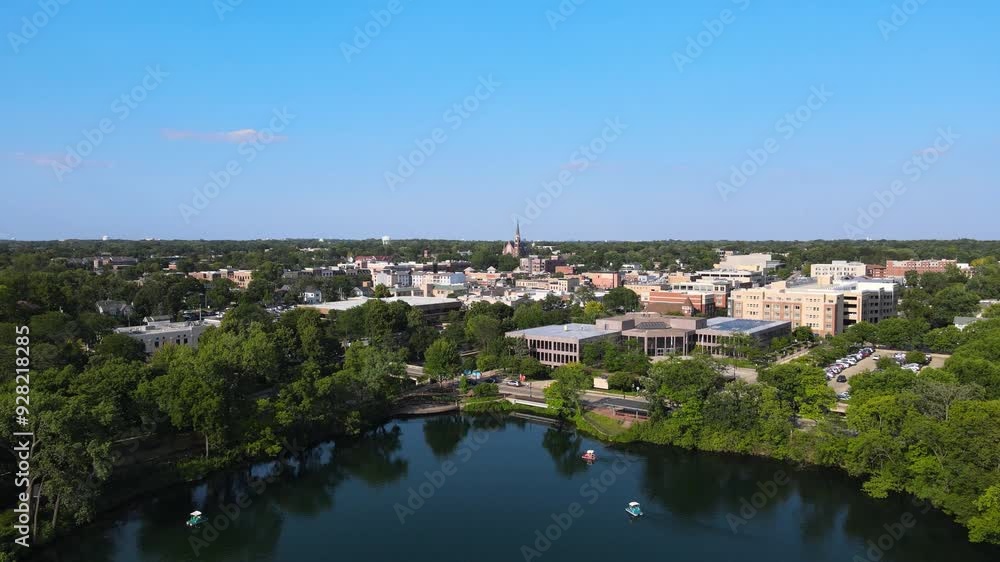 Aerial view of Quarry Lake in downtown Naperville IL with surrounding trees and buildings. Crane Up Day Aerial view of Quarry Lake in downtown Naperville IL with surrounding trees and buildings. Crane Up Day