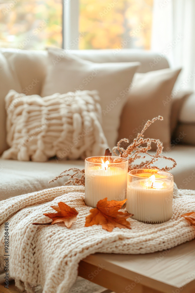 Soft autumnal candlelight creates a cozy and warm atmosphere in a neutral-toned living room. Soft autumnal candlelight creates a cozy and warm atmosphere in a neutral-toned living room.
