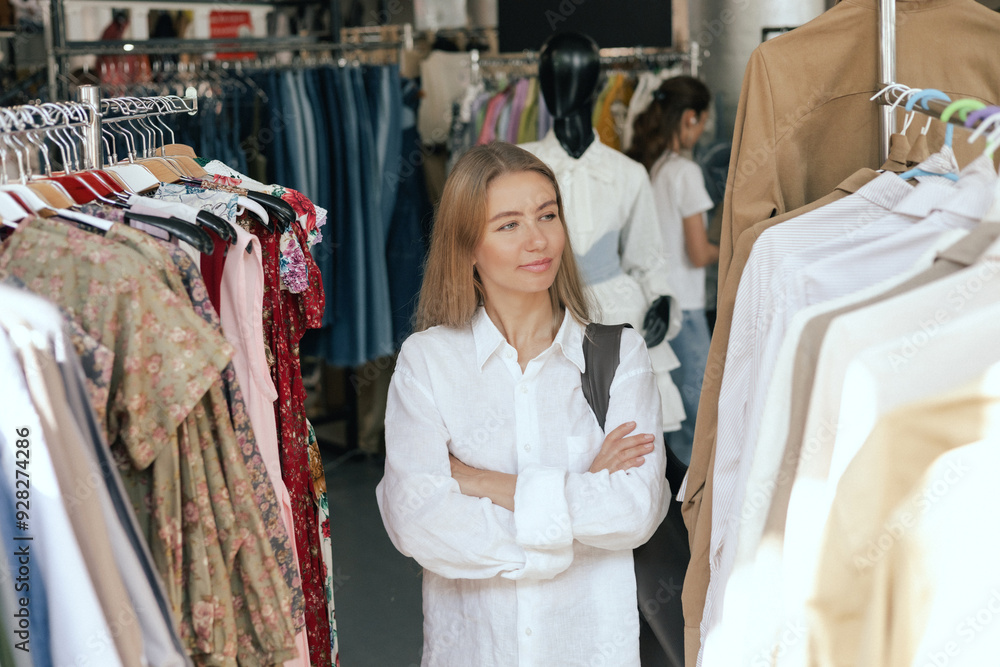 Middle aged woman runs across a rack of clothes in a shopping mall. Close-up of female hands plucked hanger choosing clothes in clothing store. Sale promotion and shopping concept. Middle aged woman runs across a rack of clothes in a shopping mall. Close-up of female hands plucked hanger choosing clothes in clothing store. Sale promotion and shopping concept.