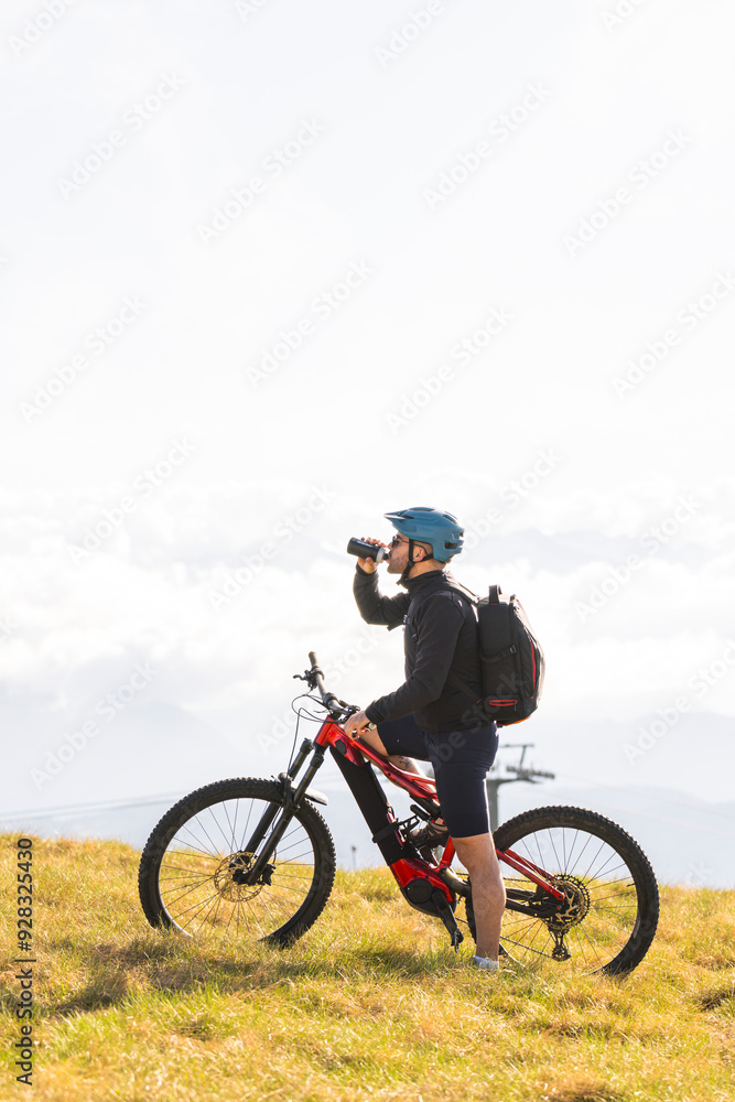 Cyclist drinking water after mountain biking Cyclist drinking water after mountain biking