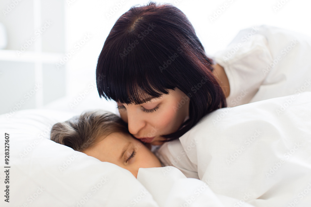 Mother tenderly kissing her sleeping child in cozy bedroom setting. Warm, loving moment captures bond and affection between parent and child. Quiet, peaceful scene emphasizing love and care. Mother tenderly kissing her sleeping child in cozy bedroom setting. Warm, loving moment captures bond and affection between parent and child. Quiet, peaceful scene emphasizing love and care.