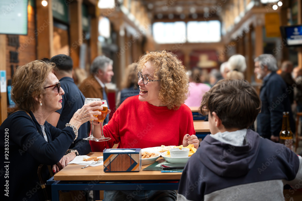 Three generations family enjoying a meal and drinks at an indoor market Three generations family enjoying a meal and drinks at an indoor market