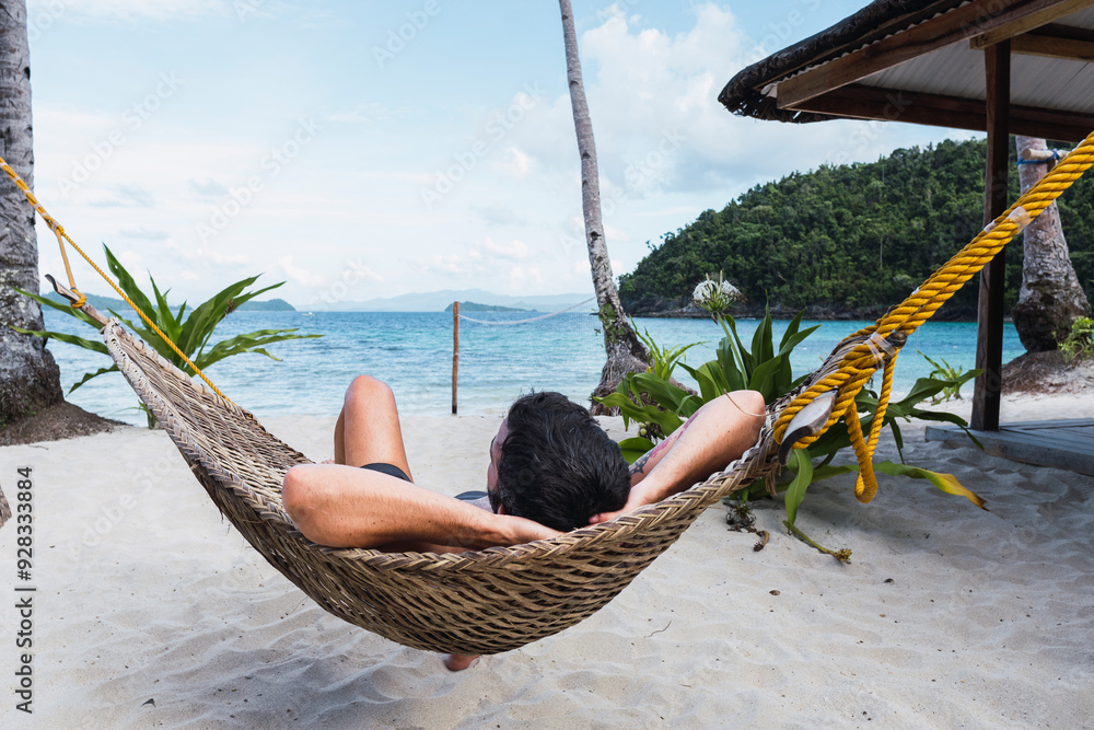 © Westend61 - Man lying on hammock at beach near sea © Westend61 - Man lying on hammock at beach near sea