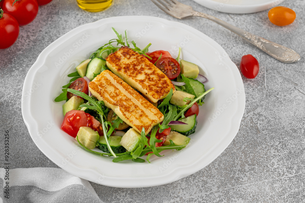 Salad with grilled halloumi cheese, tomatoes, avocado, cucumber and olive oil on a concrete background. Healthy food. Top view Salad with grilled halloumi cheese, tomatoes, avocado, cucumber and olive oil on a concrete background. Healthy food. Top view