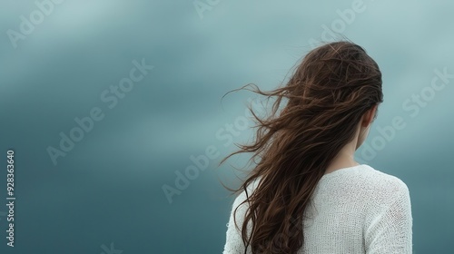 A woman stands strong against a stormy backdrop, unwavering spirit, overcoming challenges with resilience, realistic depiction, depth of focus. photo