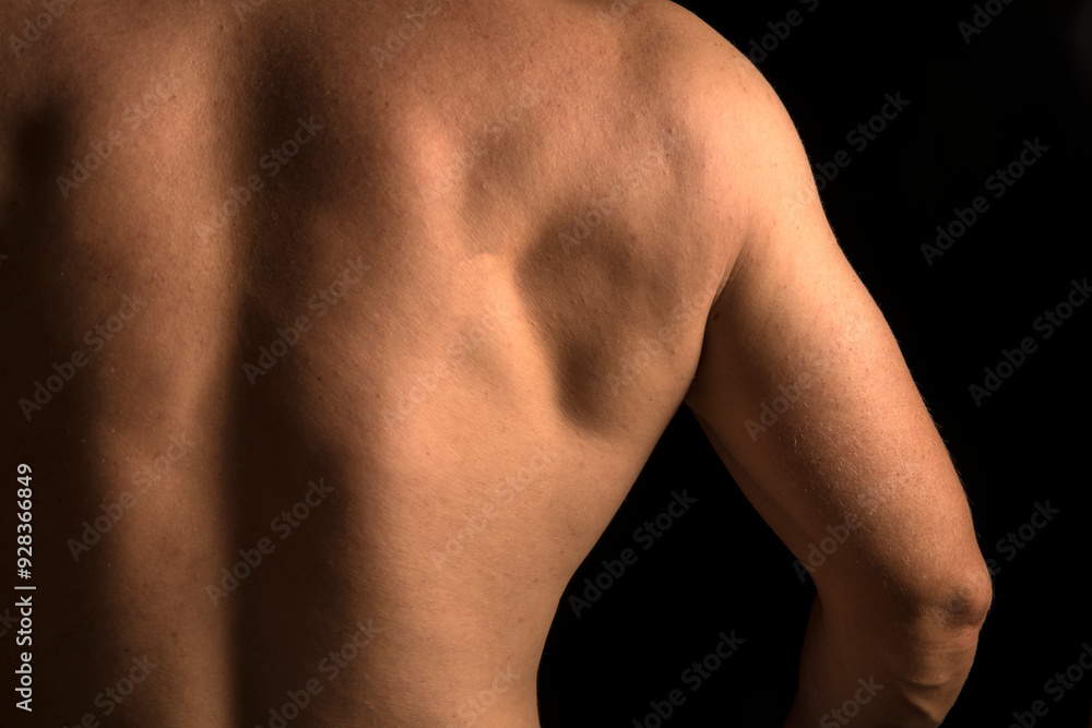 Fototapeta premium Strong athletic man back on dark background 