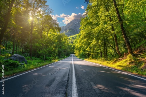 Scenic summer road through Italian forest at sunset with mountains trees and sunlight Empty asphalt road in woodland with blue sky and rock