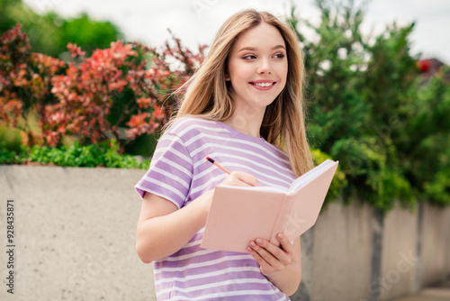 Photo of adorable sweet lady wear striped t-shirt smiling enjoying writing diary outdoors urban city street