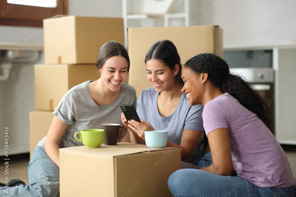 Three roommates checking smart phone moving house Three roommates checking smart phone moving house