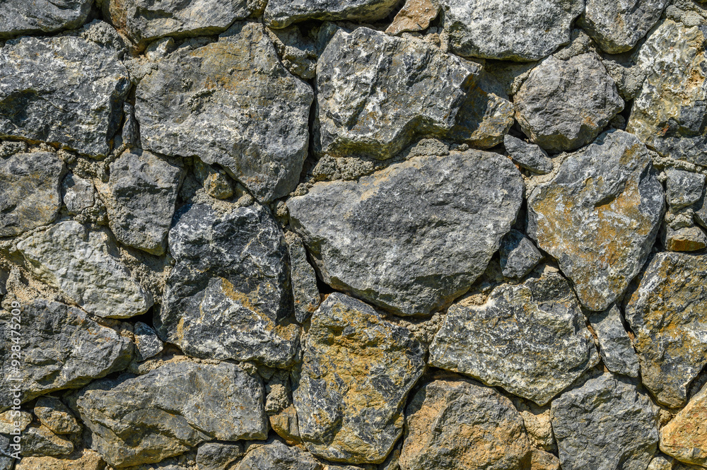Stone wall texture background - grey stone siding with different sized stones Stone wall texture background - grey stone siding with different sized stones