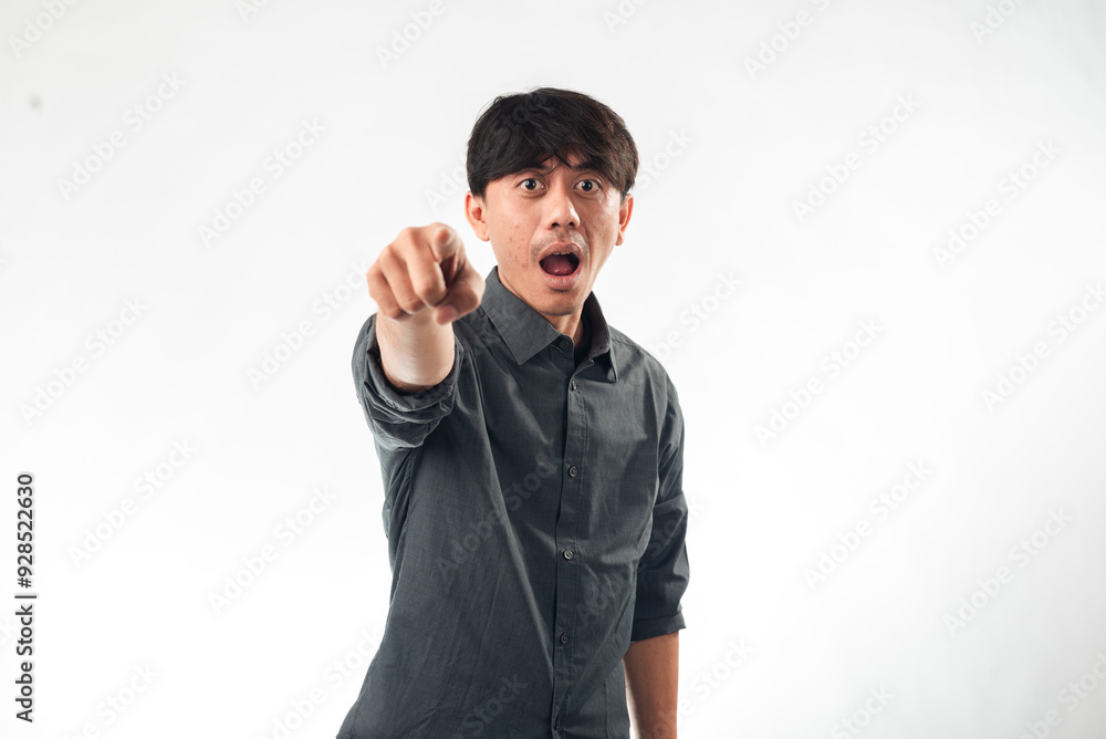 An Asian man in a gray shirt points directly at the camera with an expression of surprise and shock, mouth open, wide eyes, standing against a plain white background. An Asian man in a gray shirt points directly at the camera with an expression of surprise and shock, mouth open, wide eyes, standing against a plain white background.