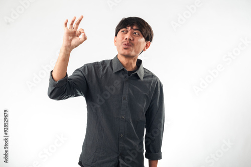 An Asian man in a gray shirt making an 