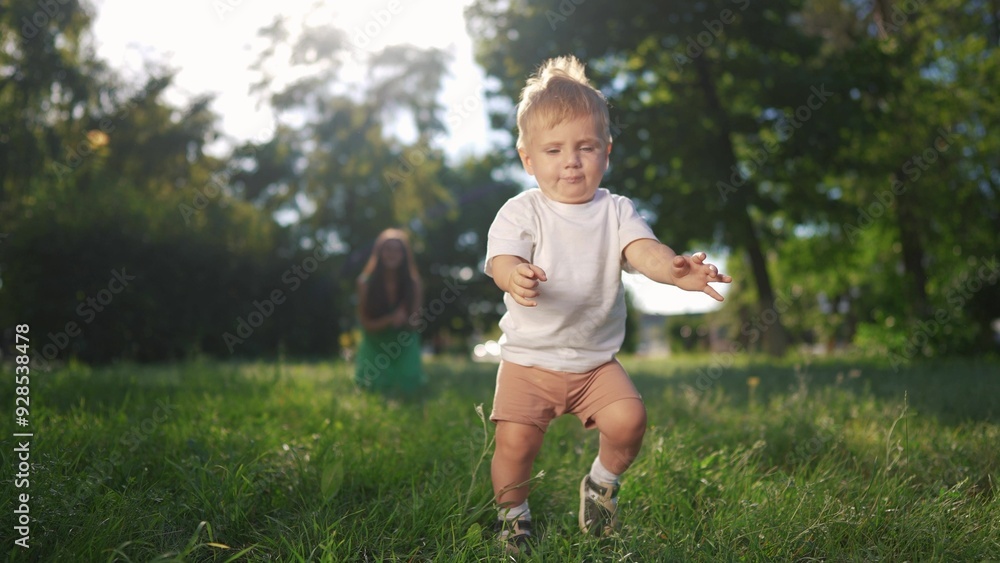 Happy family. Mother and son take their first steps. Child mother step concept. A baby is taking the first steps in the grass. Mom and baby lifestyle taking first steps in the grass. Happy family. Mother and son take their first steps. Child mother step concept. A baby is taking the first steps in the grass. Mom and baby lifestyle taking first steps in the grass.