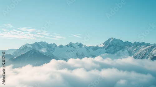 Mountains rise dramatically above a sea of clouds under a bright blue sky, creating a stunning natural landscape