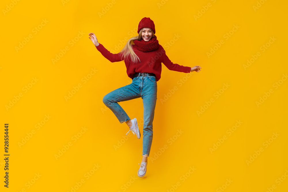 Young beautiful girl in blue warm clothes jumping up, demonstrating dancing moves Young beautiful girl in blue warm clothes jumping up, demonstrating dancing moves
