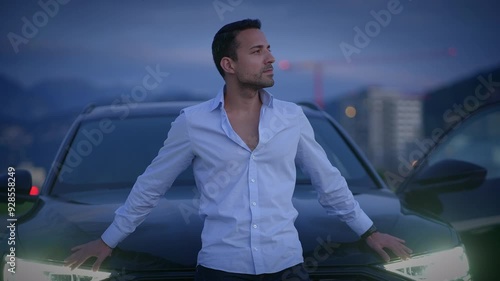 A Stylish Man Posing Confidently by a Luxury Car at Dusk, Embodying Modern Glamour photo