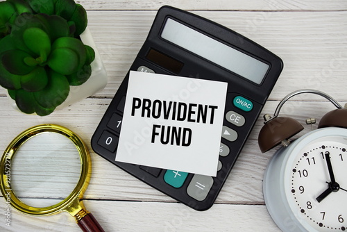 Provident Fund text message with calculate, alarm clock and magnifying glass on wooden background photo