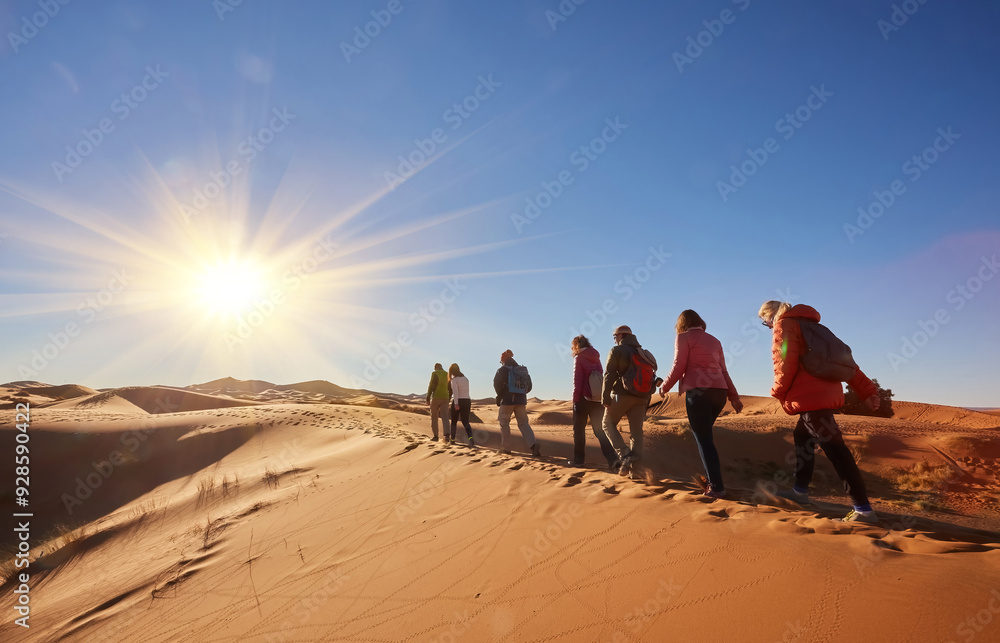 Obraz premium A group of tourists explores the majestic sand dunes of the Sahara Desert