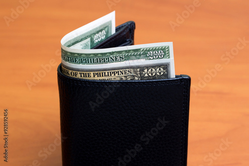 Old Philippine peso in the black wallet