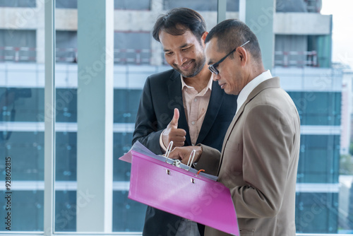 Businessmen discussing documents with a positive gesture. photo