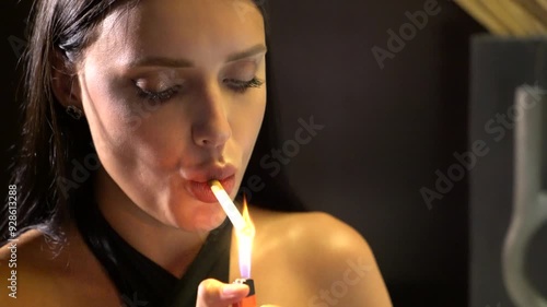 Young beautiful female fashion model smoke the cigarette. pretty woman wears elegant black clothes and reads the book