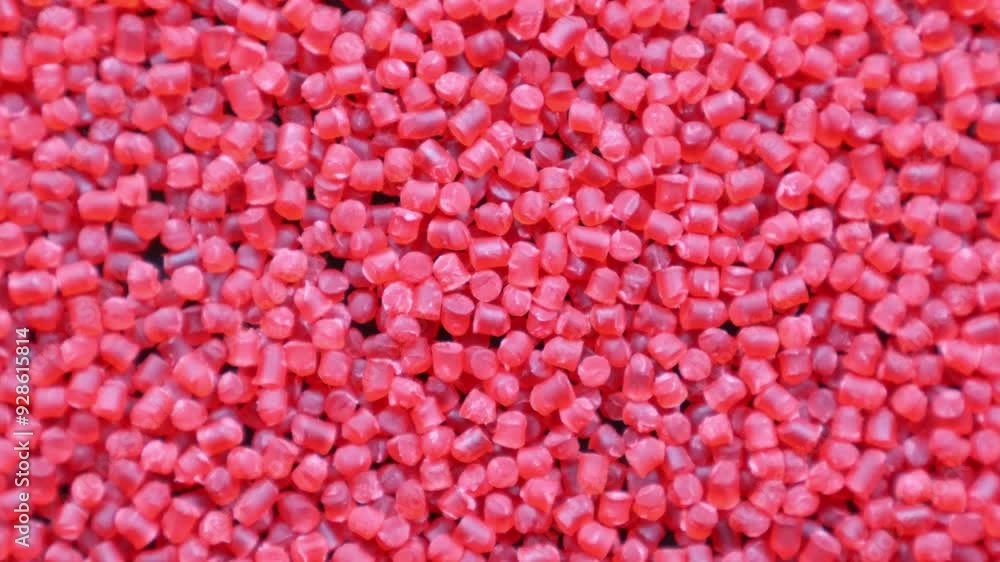 Polymer granules and plastic granules red color that spin on themselves Polymer granules and plastic granules red color that spin on themselves
