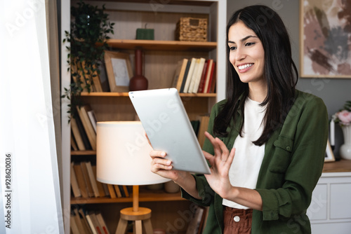 Real estate agent with tablet pc looking through window. Young business woman working at home, using device gadget. Successful professional occupation graphic designer female taking a break from work.