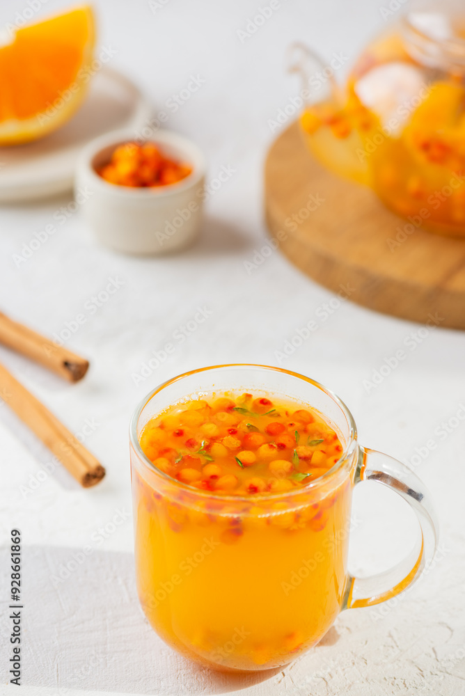 Sea buckthorn tea with orange, cinnamon and thyme in glass. Herbal vitamin tea. Hot autumn drink. Vertical orientation. Sea buckthorn tea with orange, cinnamon and thyme in glass. Herbal vitamin tea. Hot autumn drink. Vertical orientation.