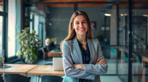 Free Download Confident businesswoman with crossed arms smiling in modern office, facing camera, embodying success in professional attire with sleek hairstyle. - GFXLoad