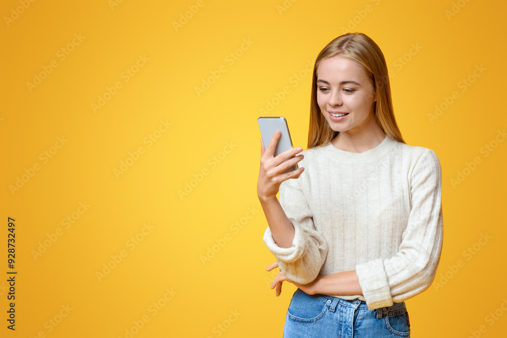 Nice App. Beautiful teen girl holding and using smartphone over orange studio background, copy space Nice App. Beautiful teen girl holding and using smartphone over orange studio background, copy space