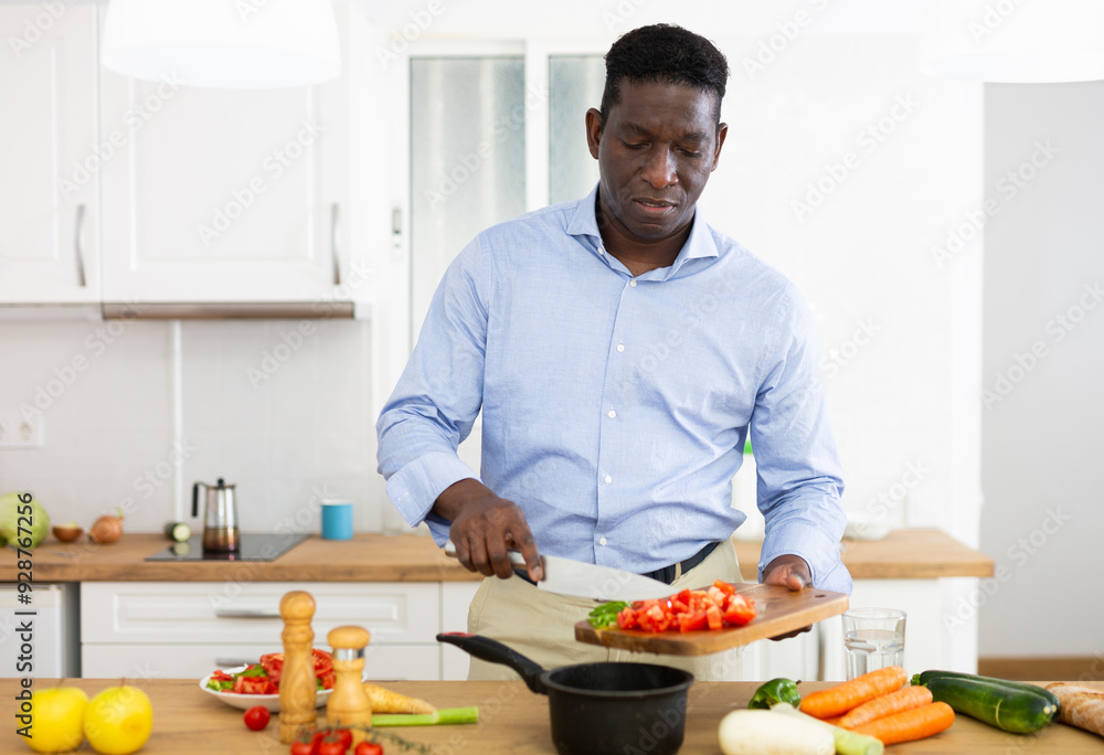 Smiling african american man eating apple in home kitchen Smiling african american man eating apple in home kitchen